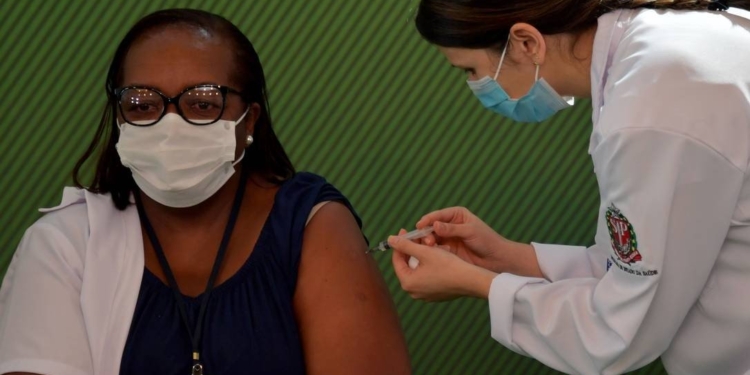 Vai começar a vacinação: Mônica Calazans, 54 anos, recebe a primeira dose da CoronaVac em São Paulo
